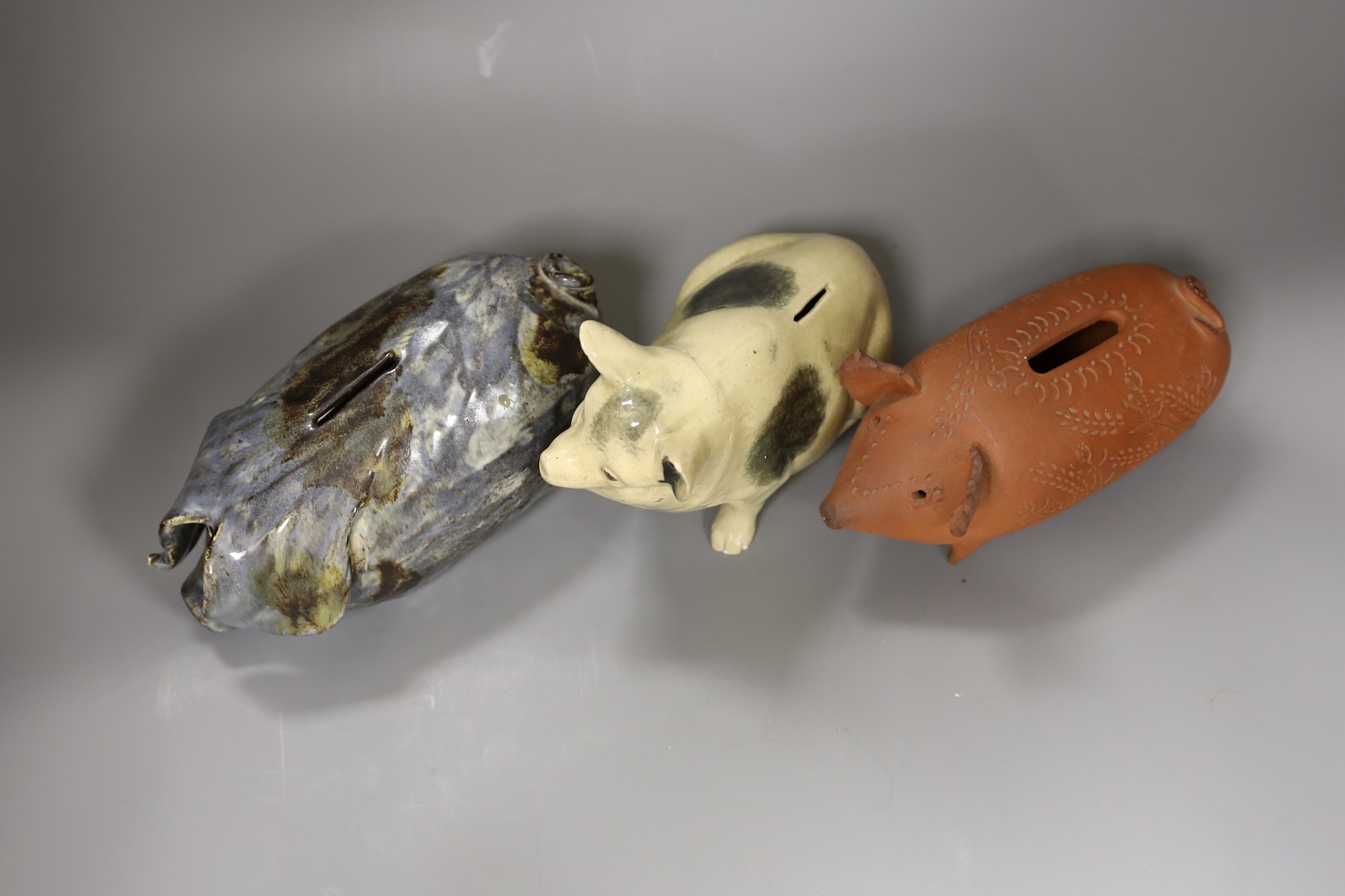 An early 20th century glazed pottery pig and 2 studio pottery pigs by Paul Whalley and Quinnett Rushett, tallest 15cm